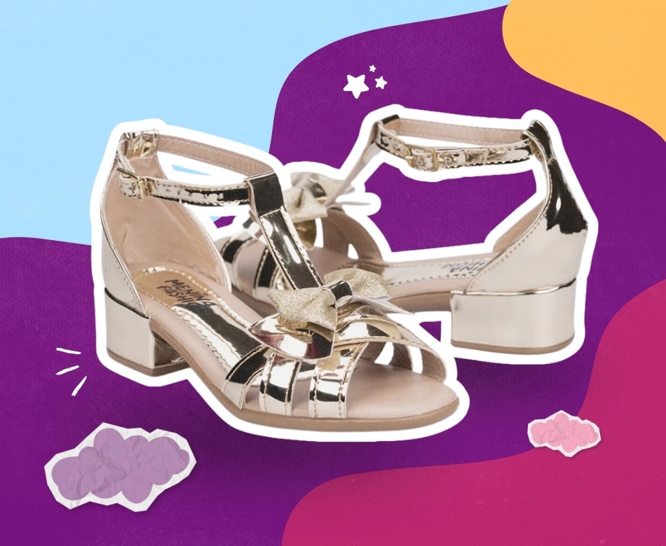 Sandália infantil feminina de salto dourada metalizada com detalhe de laço em glitter Menina Fashion. Sapato social infantil de salto baixo sobre fundo colorido