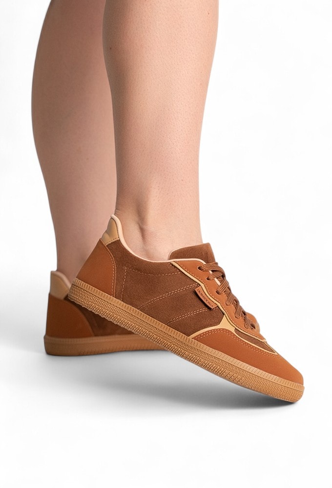 Mulher em viagem, caminhando com o Tênis Feminino Retrô Caramelo, destacando o conforto e versatilidade.