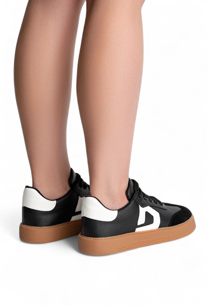 Modelo usando o Tênis Feminino Retrô preto com detalhe D branco