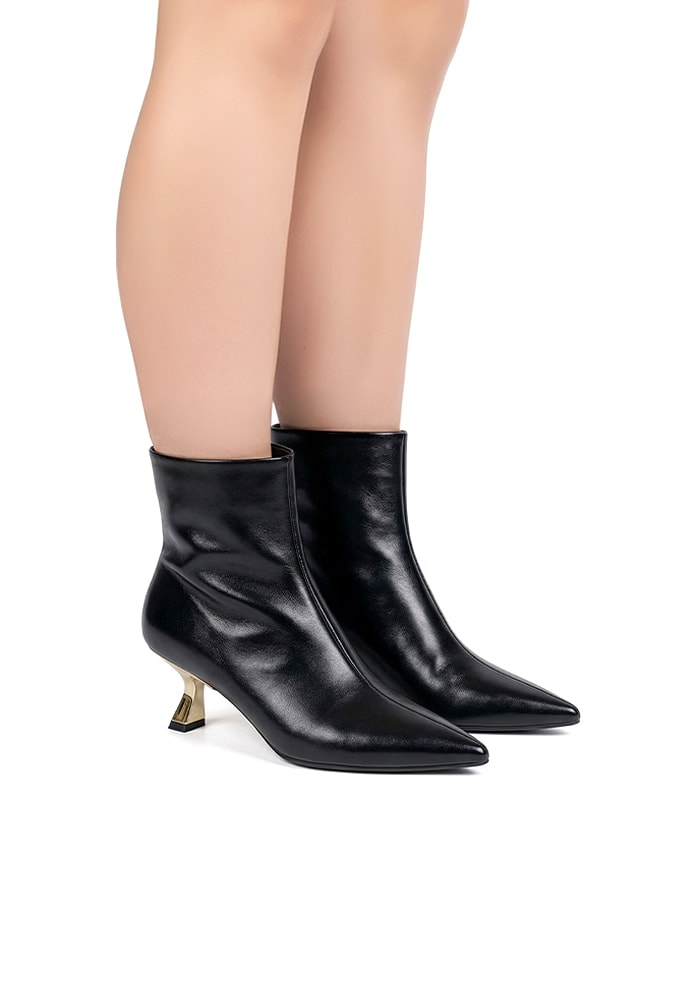 Mulher elegante usando Bota Feminina Cano Curto Preta com salto dourado e bico fino