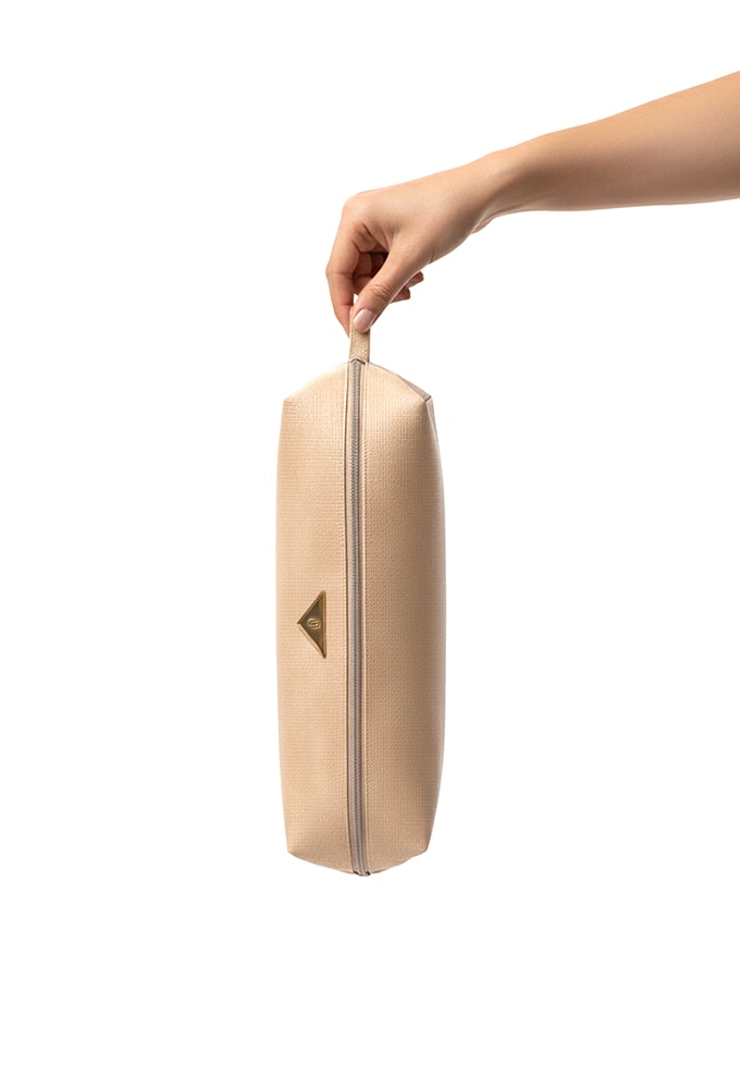 Mulher usando a Bolsa Nécessaire Natural Domidona em trama sintética estilo palha.